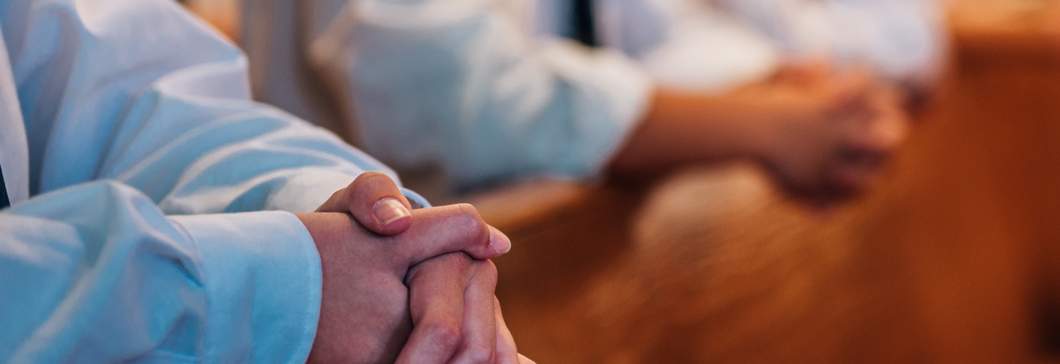 Praying hands in pew